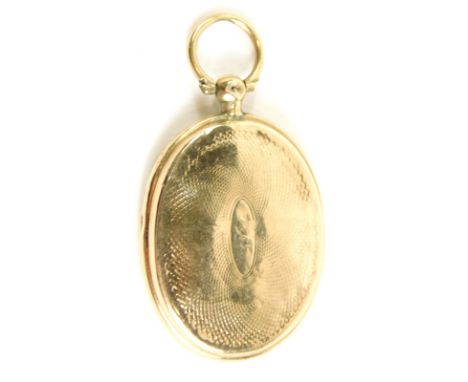 A heart locket, with ring top and oval body, engine turned with central vacant cartouche and plain interior, yellow metal unm
