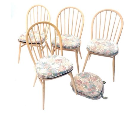 A set of four Ercol beech and light elm stick back dining chair, each with a hoop back, solid seat on turned legs.