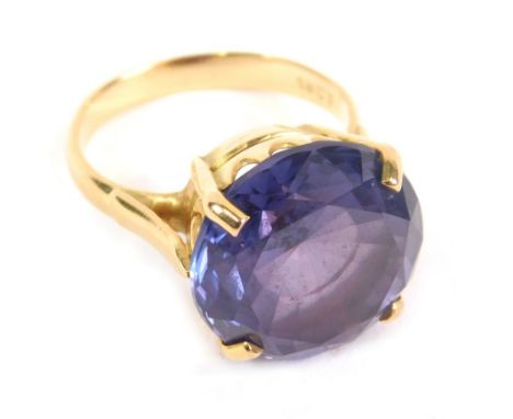 A dress ring, claw set with large amethyst coloured stone, the part pierced shank marked 18ct, size N.