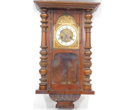 An early 20thC walnut Vienna wall clock, the domed 13cm diameter enamel dial with Roman numerals, with rasied spandrels flank