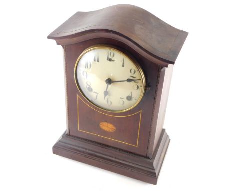 An Edwardian mahogany mantel clock, the serpentine top raised above a 13cm diameter Arabic case, in inlaid case on orb feet w