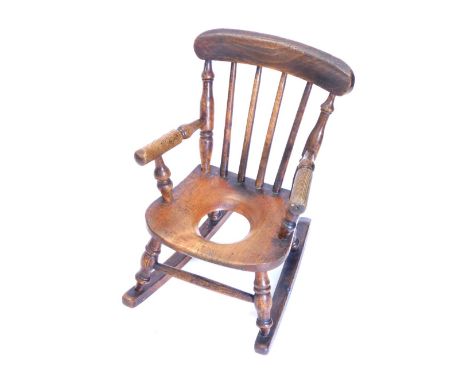 A 19thC child's ash and elm rocking commode Windsor chair, with turned supports, 36cm wide.