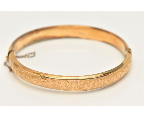 AN EARLY 20TH CENTURY 9CT GOLD HINGED BANGLE, foliate leaf pattern, hinged opening, push button clasp with additional safety 