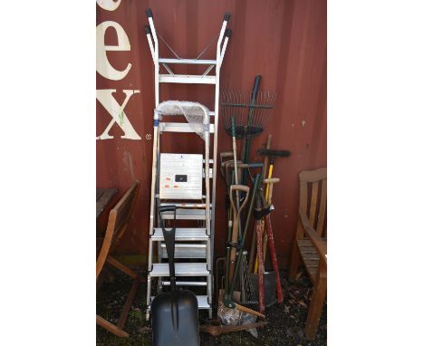 A SELECTION OF GARDEN ITEMS, to include three bundles of spades, rakes, shovels, etc, along with an aluminium step ladder and