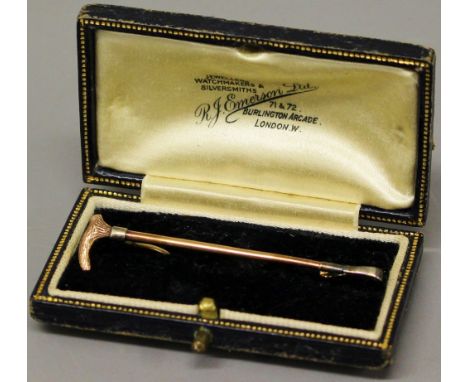 A 9ct gold stock pin in the form of a hunting whip (boxed).