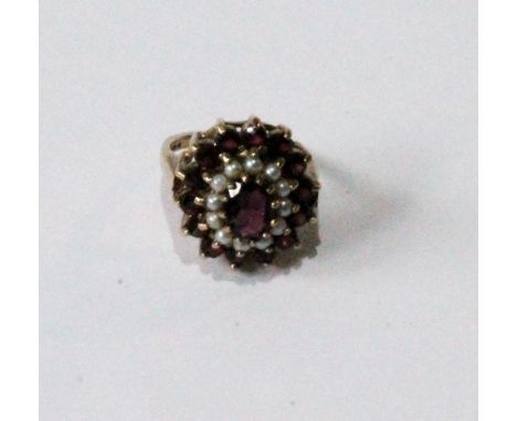 Dress ring with oval cluster of garnets and pearls in 9ct gold.