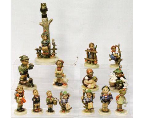 Goebel Hummel table lamp in the form of a boy on a fence, 24cm high, together with thirteen various Goebel Hummel figures.  (