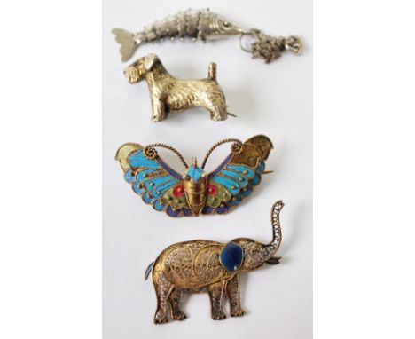 Silver brooch modelled as a Scottie, another, Chinese, as a butterfly, a filigree elephant brooch and a fish pendant.