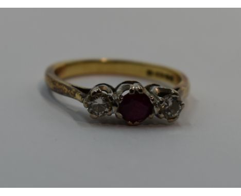 A lady's dress ring having a central ruby flanked by two diamonds, each stone approx 0.128ct in a claw set mount on an 18ct g