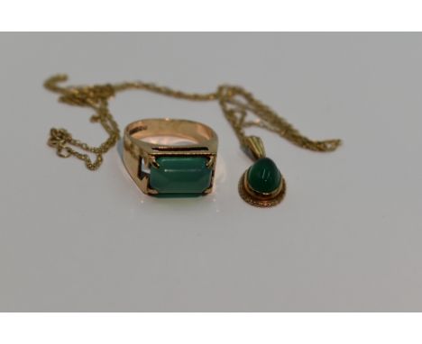 A green cabouchon pendant of oval form in a 9ct gold mount on a 9ct gold chain, approx 18' with a matching dress ring of styl