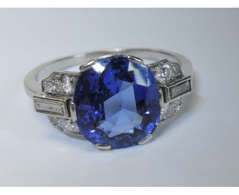 A lady's 1950's dress ring having a large central sapphire, approx 4ct in a six claw setting flanked by baguette and brillian