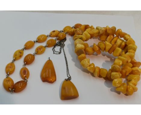 Four pieces of Russian butter scotch amber including a string of rough cut beads, a pendant on a Russian silver chain, a pend