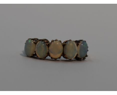 A lady's dress ring having five oval opal cabouchons of even form in a claw set mount on a yellow metal loop stamped 9ct, siz