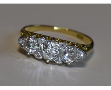 A Victorian lady's dress ring having three graduated diamonds with a border of six diamond chips, total approx 1.6ct in a mou