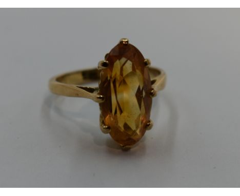 A lady's dress ring having a lozenge shaped citrine in a claw set basket mount on a yellow metal loop stamped 9ct gold, size 