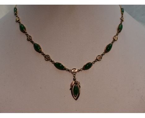 A jade necklace having eight lozenge shaped panels with a pendant drop and decorative connector links on a fixed chain stampe