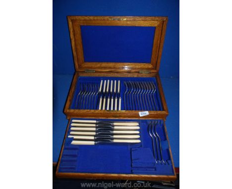 A Victorian light oak cutlery canteen with part contents.