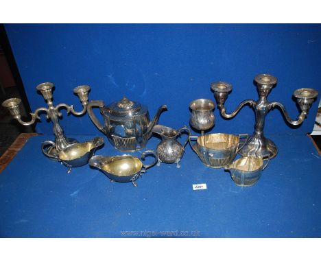A quantity of plated items including three piece Teaset (teapot dented), two candelabra (not matching), pair of sauce boats, 