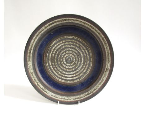 ROBIN WELCH (1936-2019) A studio pottery charger, deep blue and off-white, impressed mark underneath. 37.5cm diameter 