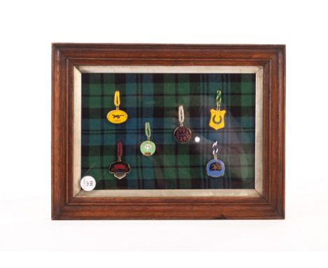 Horseracing, six Scottish racecourse enamel badges in tartan frames, including Perth, Hamilton, Kelso and others