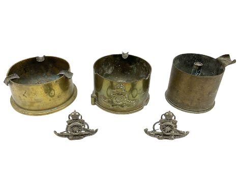 Trench Art - three WW2 brass shell case ashtrays, one mounted with Royal Artillery cap badge and button and one mounted with 