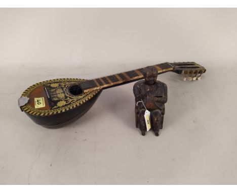 An American painted metal 'Tammany Bank' seated figure money box plus an eight string musical instrument