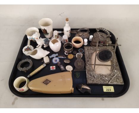 A mixed lot including crested ware, enamel pin badges, easel, plated watch stand, cased German metronome etc