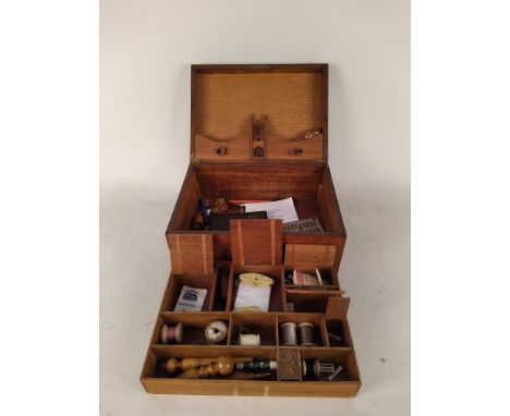 A Victorian oak sewing box with fully fitted interior with sewing tools, lid inlaid with date 1884