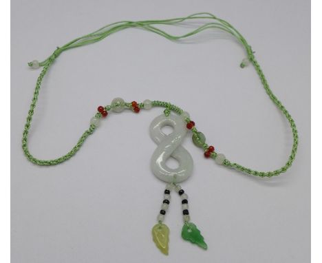 A Chinese carved jade pendant and rope chain with figure of eight symbol