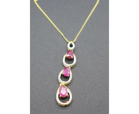 A silver gilt set ruby pendant set with two diamonds, with chain