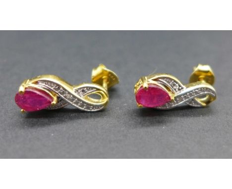 A pair of silver gilt set ruby earrings with two diamonds