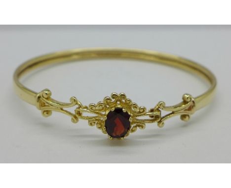 A 9ct gold and garnet bangle, 6.3g