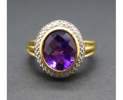 A silver gilt set amethyst ring with diamond accents, M