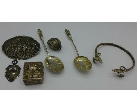 A Victorian white metal walnut charm or locket, a white metal pill box embossed with fruit, two silver spoons, a silver fob, 