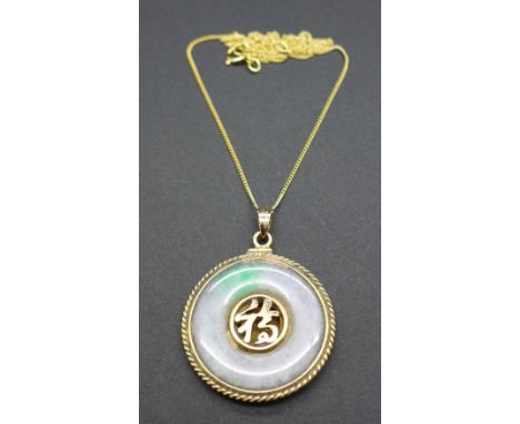 A 14ct gold and jade pendant with silver gilt chain
