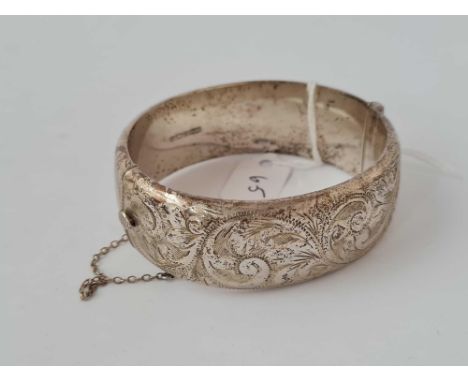 A wide silver bangle with chased decoration B'ham 1972 