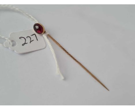 A garnet cabochon gold top stick pin