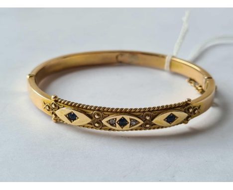 A gold bangle set with sapphire &amp; diamond