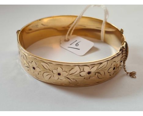 A gold plated stone set hinged bangle