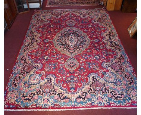 A signed Meshad carpet 350 x 255cm central double pendent medallion with repeating spandrels on a pomegranate field guarded b