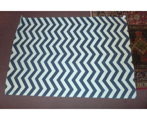 A contemporary carpet with blue and white chevron motif 230 x 160cm