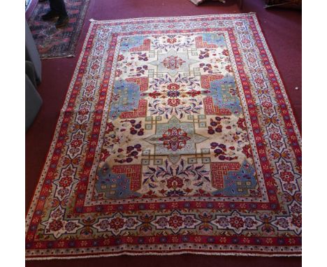 A central Persian Isfahan carpet 352 x 243cm with repeating stylised eagle Kazak motifs and repeating spandrels on an ivory f