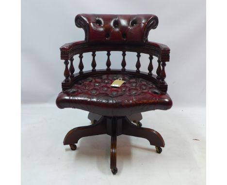 A button back red leather captains chair on swivel supports raised on castors 