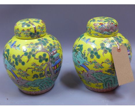 A pair of Japanese ceramic ginger jars and covers decorated with figures in a courtyard scene on a yellow ground, H 25cm