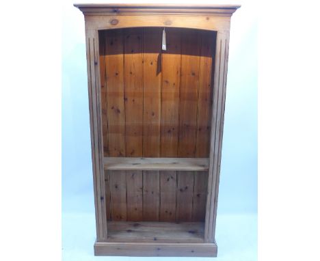A pine open bookcase with reeded columns on a step base, H 182 x W 101 x D 30cm