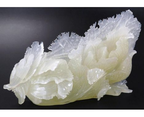 A 20thC heavily carved polished light green jade finish sculpture, of scrolls and flowers with a shaped outline, unmarked, 16
