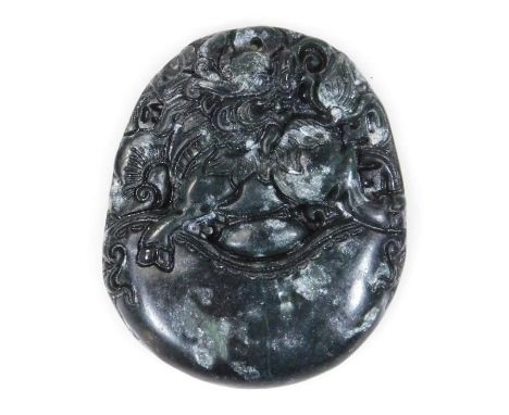 A 20thC polished spinach jade style buckle or pendant, of shaped oval outline raised with flowerheads, unmarked, 5cm high.