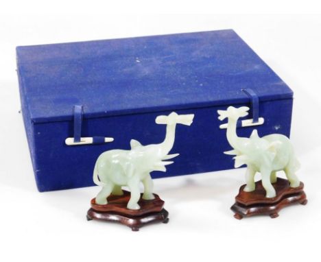 A pair of 20thC Chinese jade figures, of elephants, each with trunks raised on wooden bases, 11cm high. (boxed)