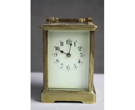 A C.1900's brass carriage clock with white enamel dial and chamfered glass panels. No key. H.6 W.4.D.3cm. 