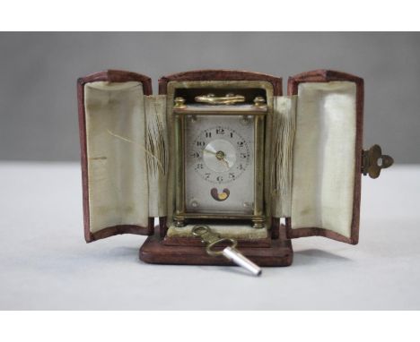A leather fitted cased miniature 19th century Swiss gilt metal and mother of pearl carriage clock. With key. Makers stamp to 